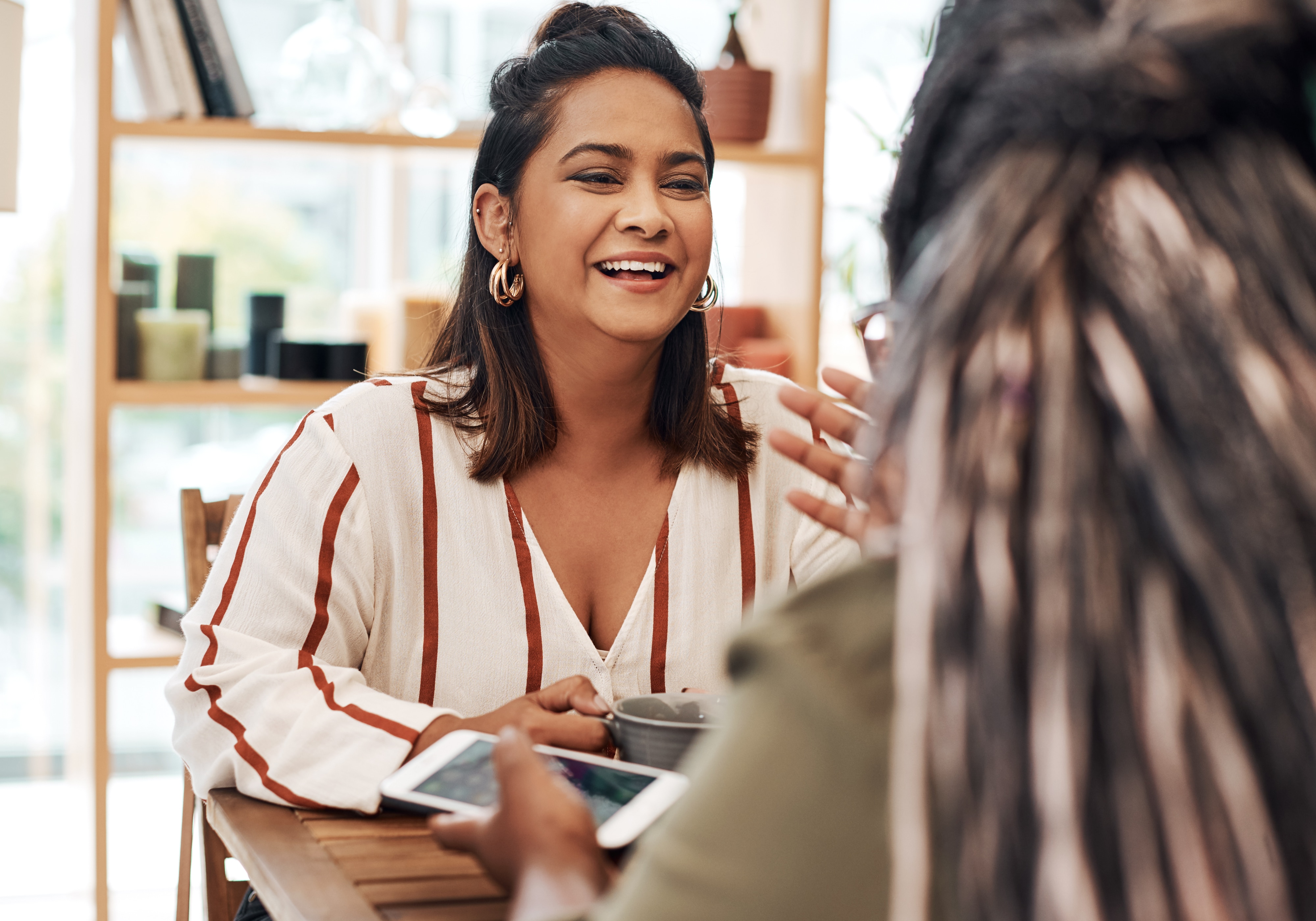 woman sitting and talking to person across the table