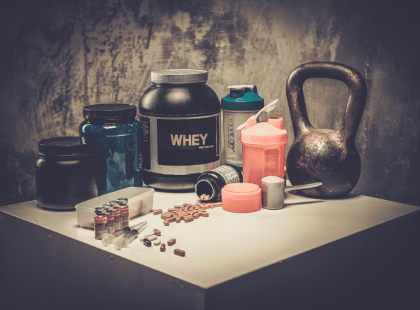 supplement containers on counter with kettlebell