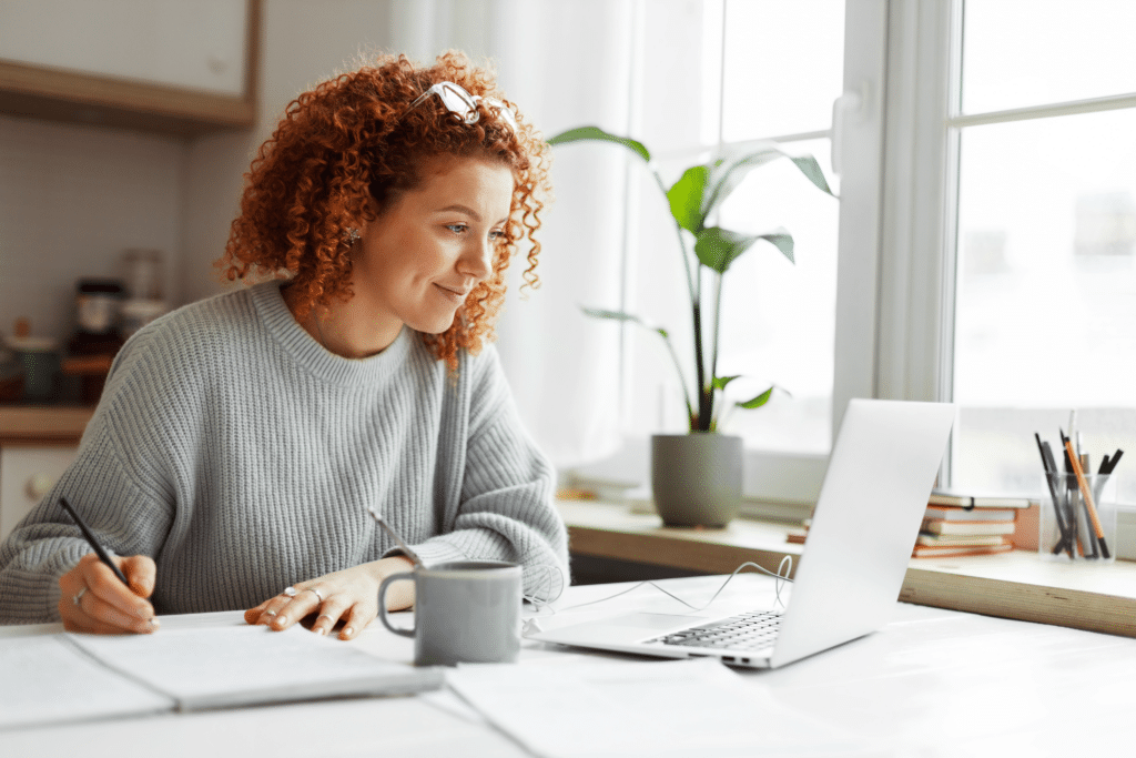 woman with curly hair studying in front of laptop